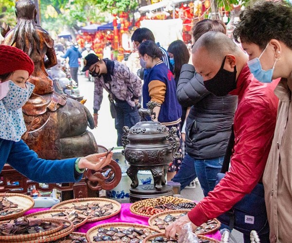 Hà Nội: Nhiều người dân đã ý thức đeo khẩu trang khi đi sắm Tết - Anh 9