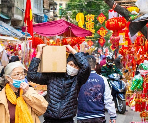 Hà Nội: Nhiều người dân đã ý thức đeo khẩu trang khi đi sắm Tết - Anh 1