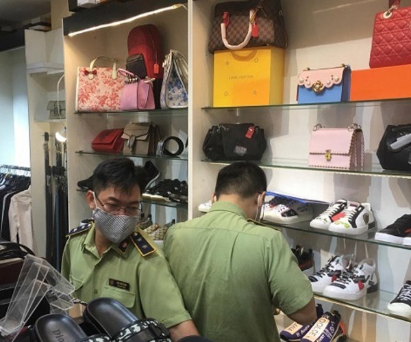 Hà Nội phát hiện, bắt giữ lượng lớn giầy dép giả, nhái nhãn hiệu nổi tiếng - Anh 1